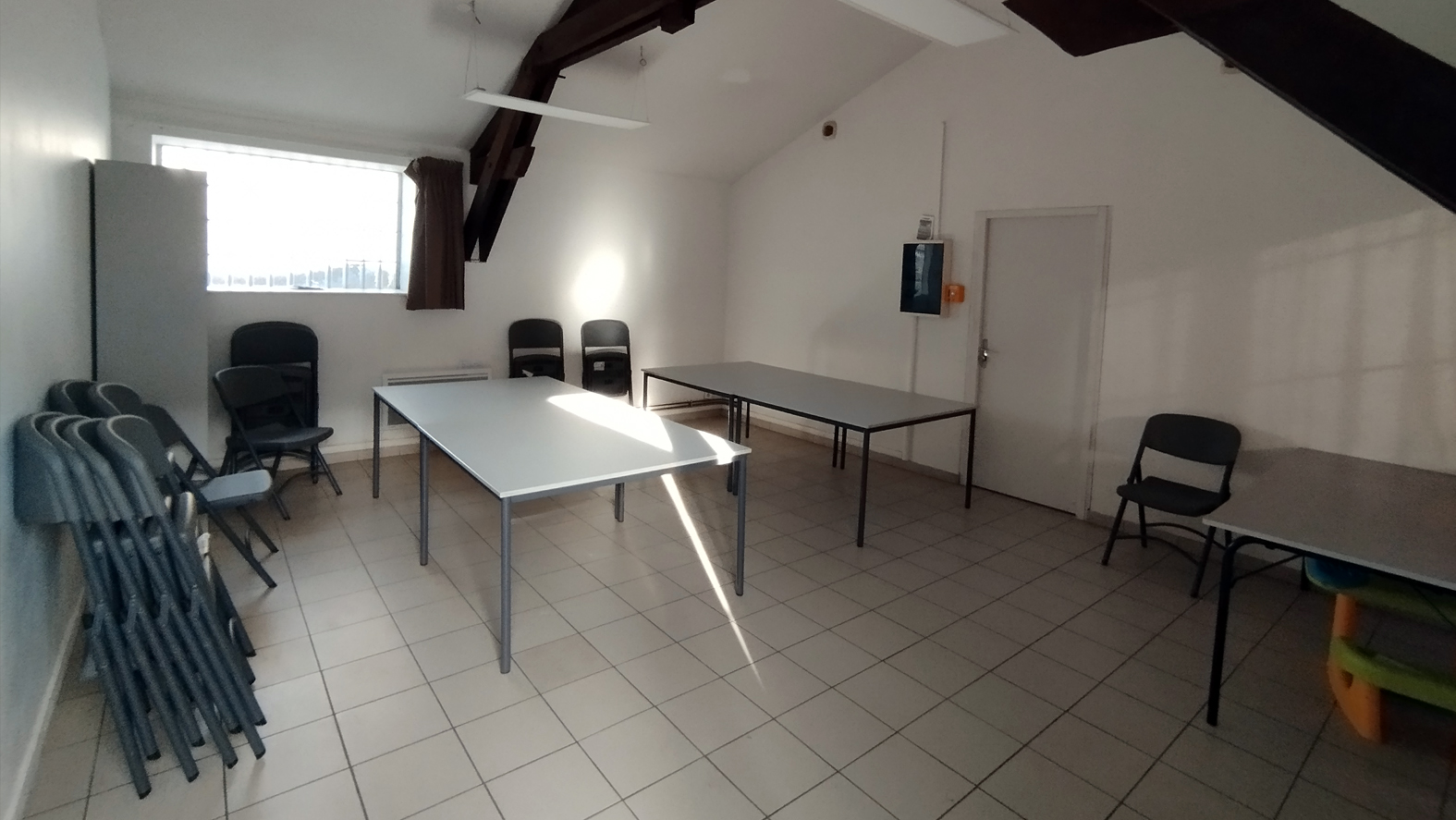 Pièce avec tables, chaises, placard, étagère, porte, fenêtre et escalier.