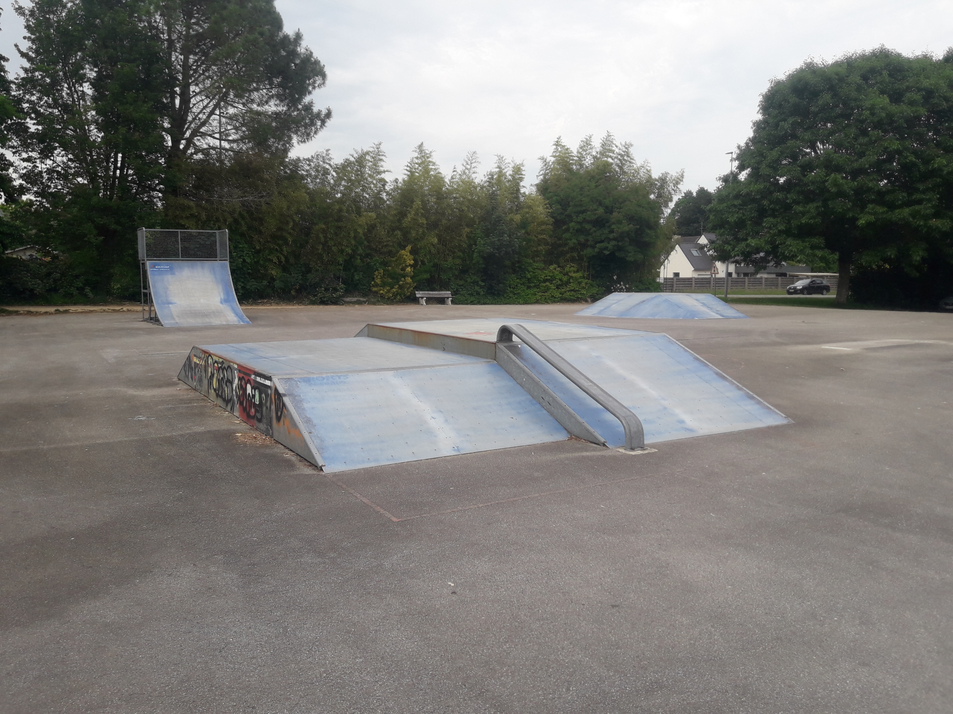 Skatepark avec rampes et modules.