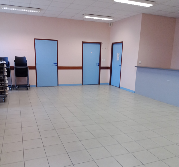 Pièces avec portes bleues et chariot métallique.