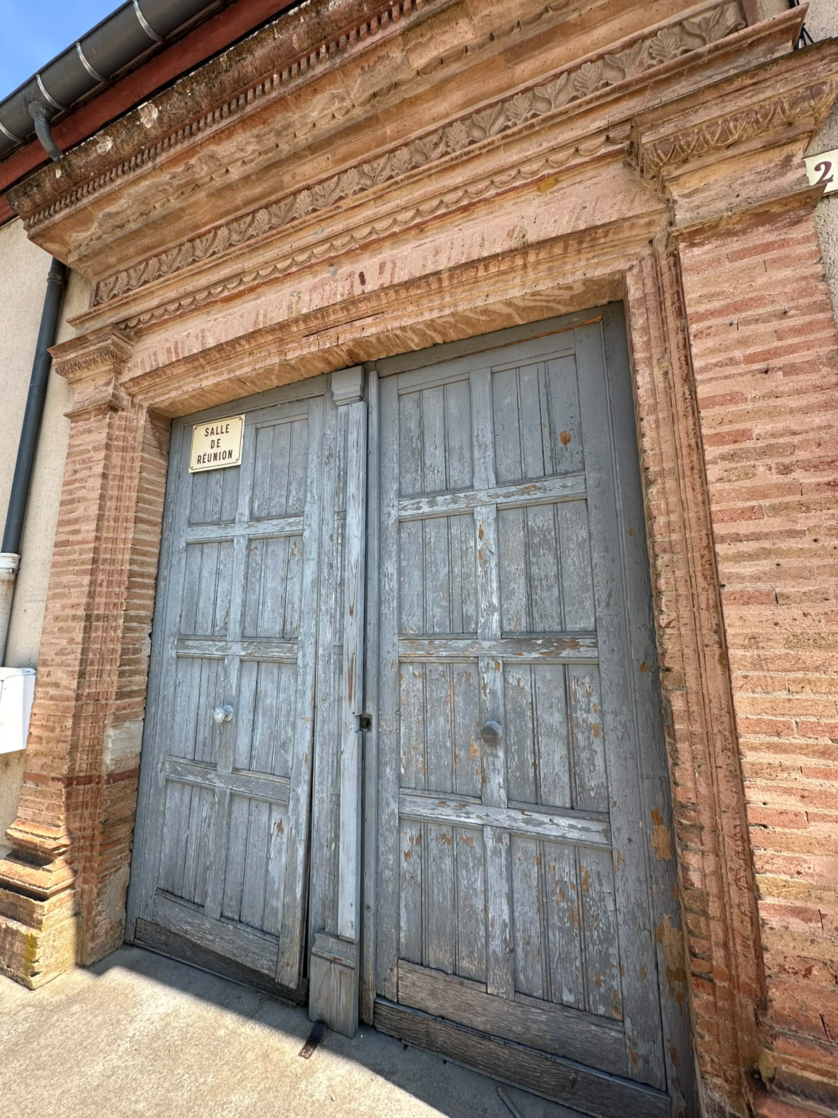 Porte en bois usée avec encadrement en brique.