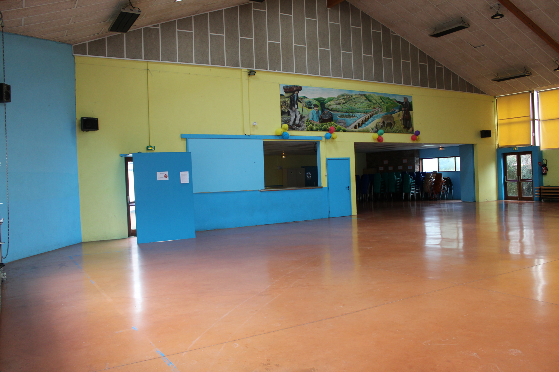 Salle avec comptoir, portes, chaises et table à l'arrière-plan.
