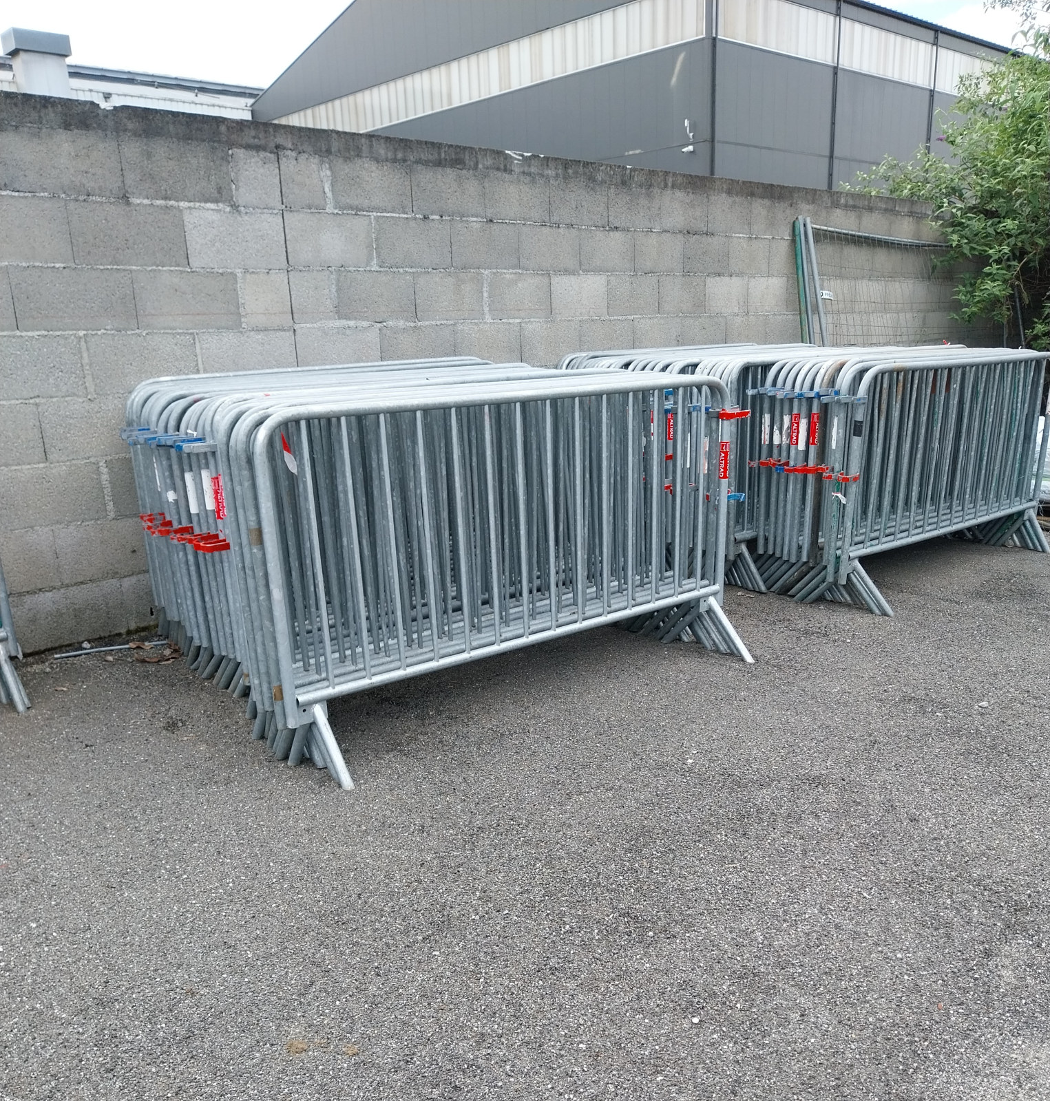 Barrières métalliques empilées contre un mur de briques.