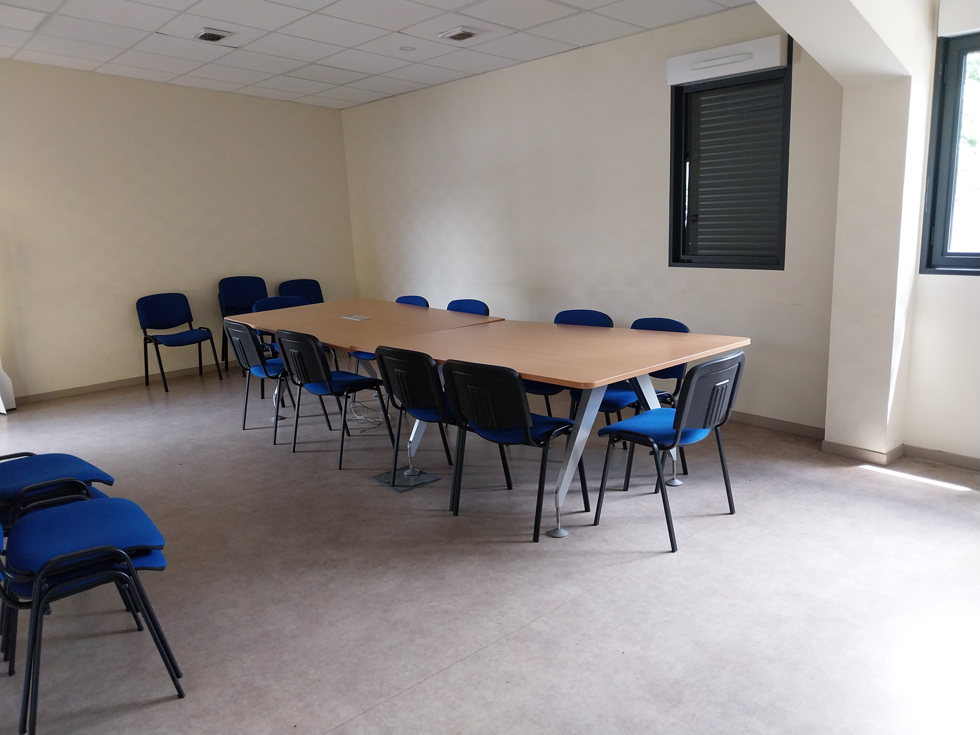Salle avec table, chaises et fenêtre.
