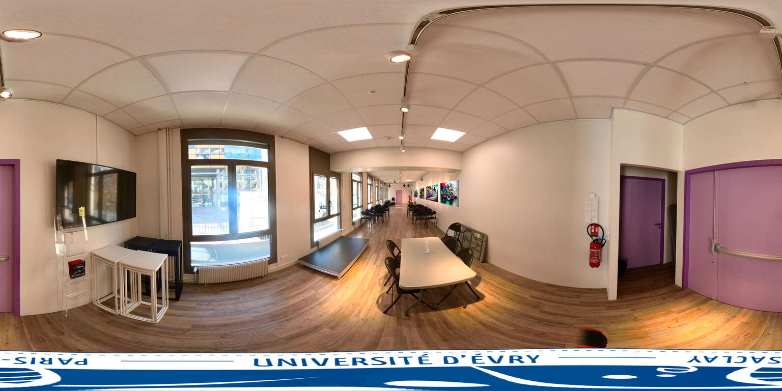 Salle avec écran, table, chaises, extincteur, portes et fenêtres.