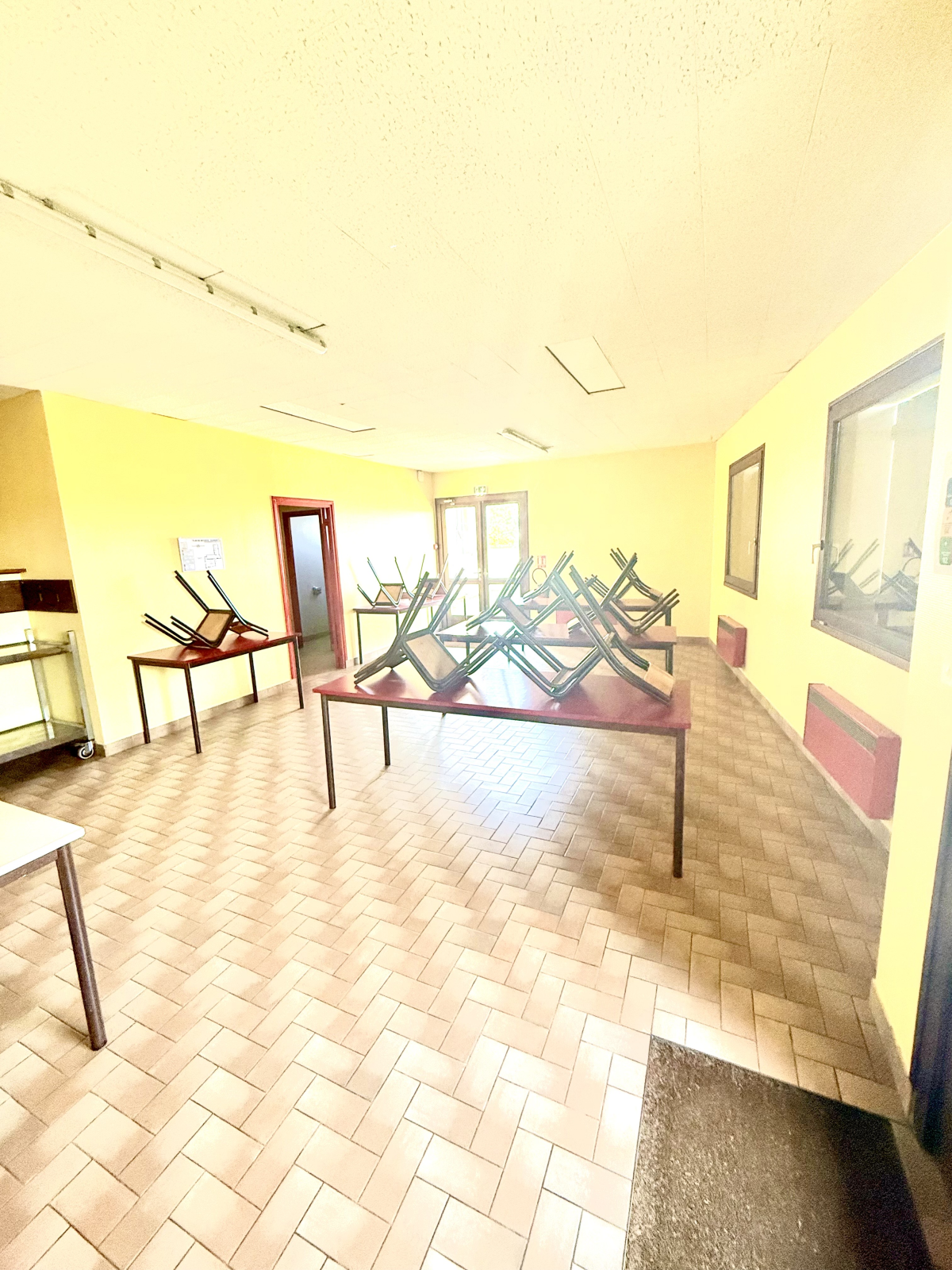 Pièces vides avec tables, chaises et structures métalliques.