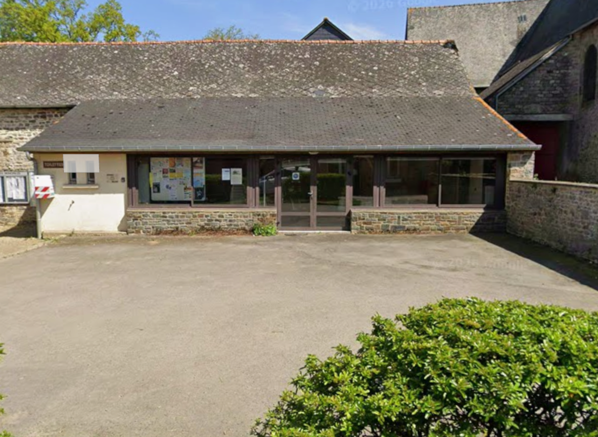 Bâtiment avec toiture en ardoise, murs en pierre, portes vitrées, fenêtres et parking.