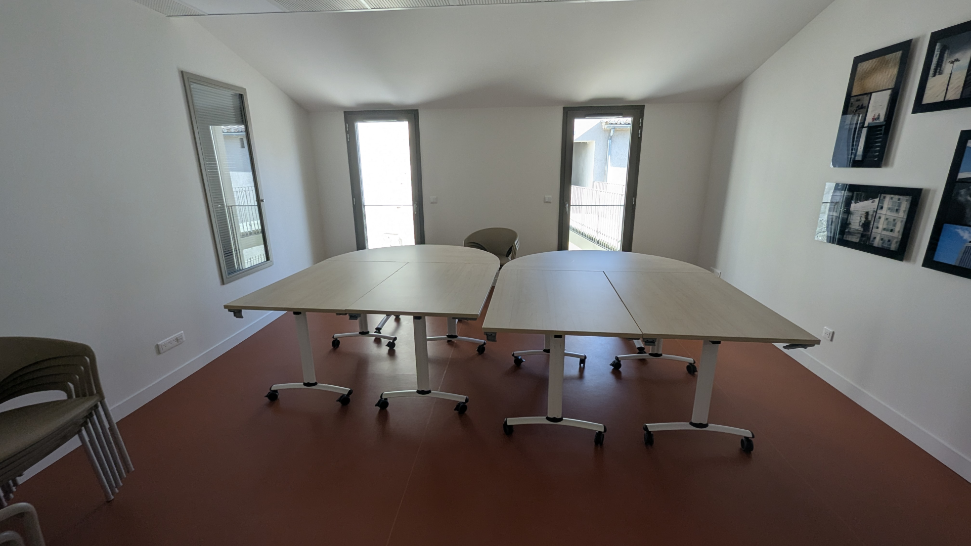 Salle avec tables, chaises, et photos murales.