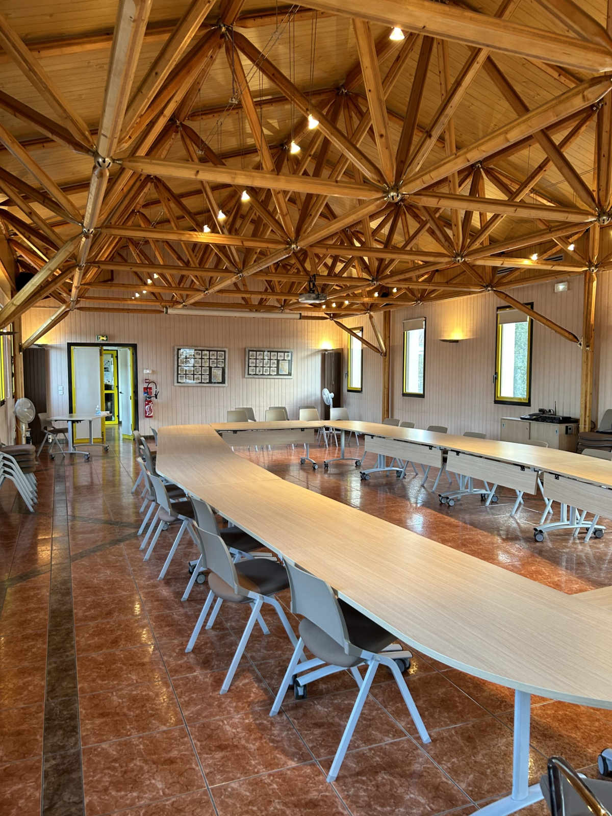 Salle de réunion avec table, chaises, ordinateur et écran.