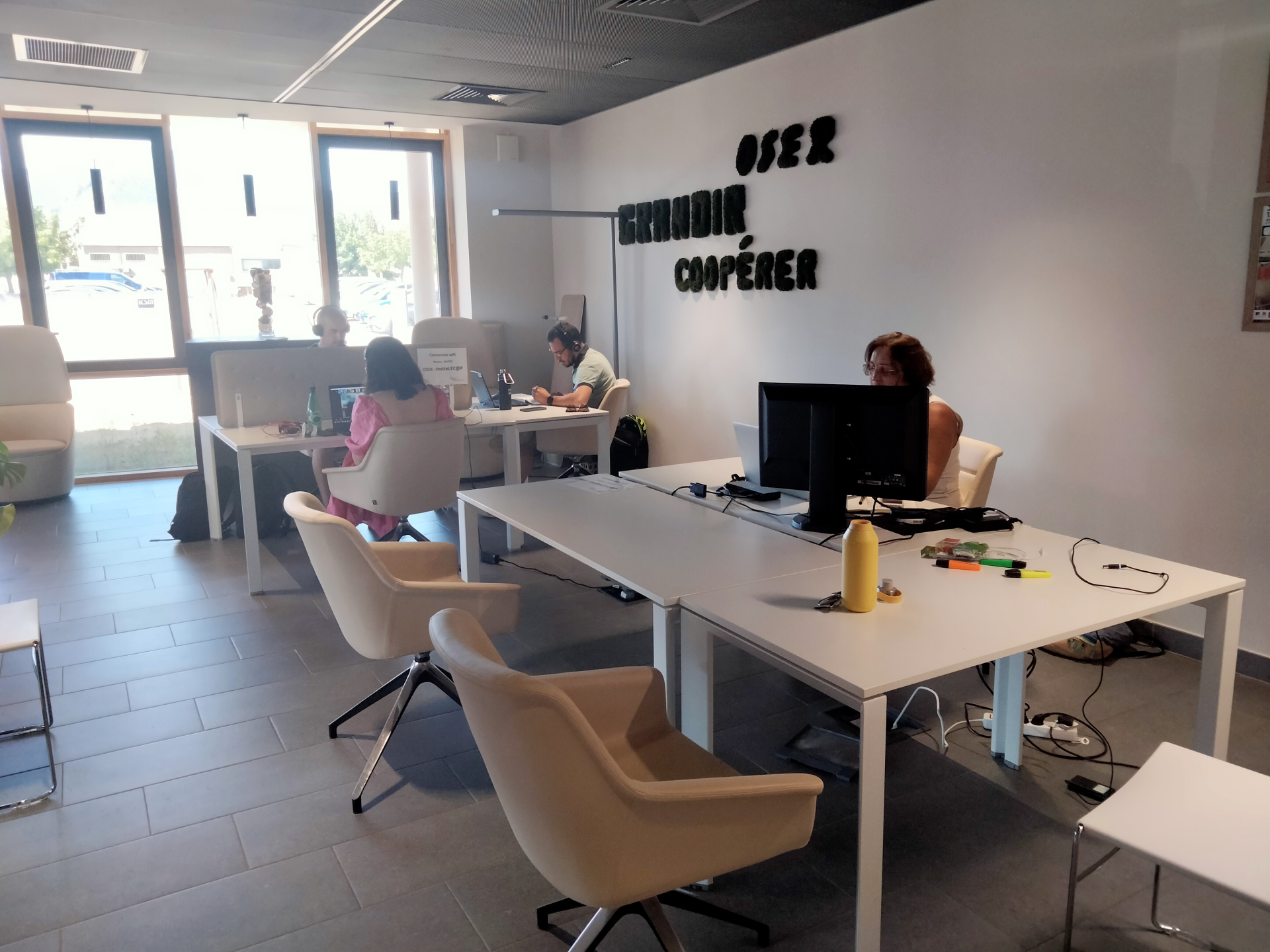 Bureaux avec moniteurs, chaises, accessoires informatiques.