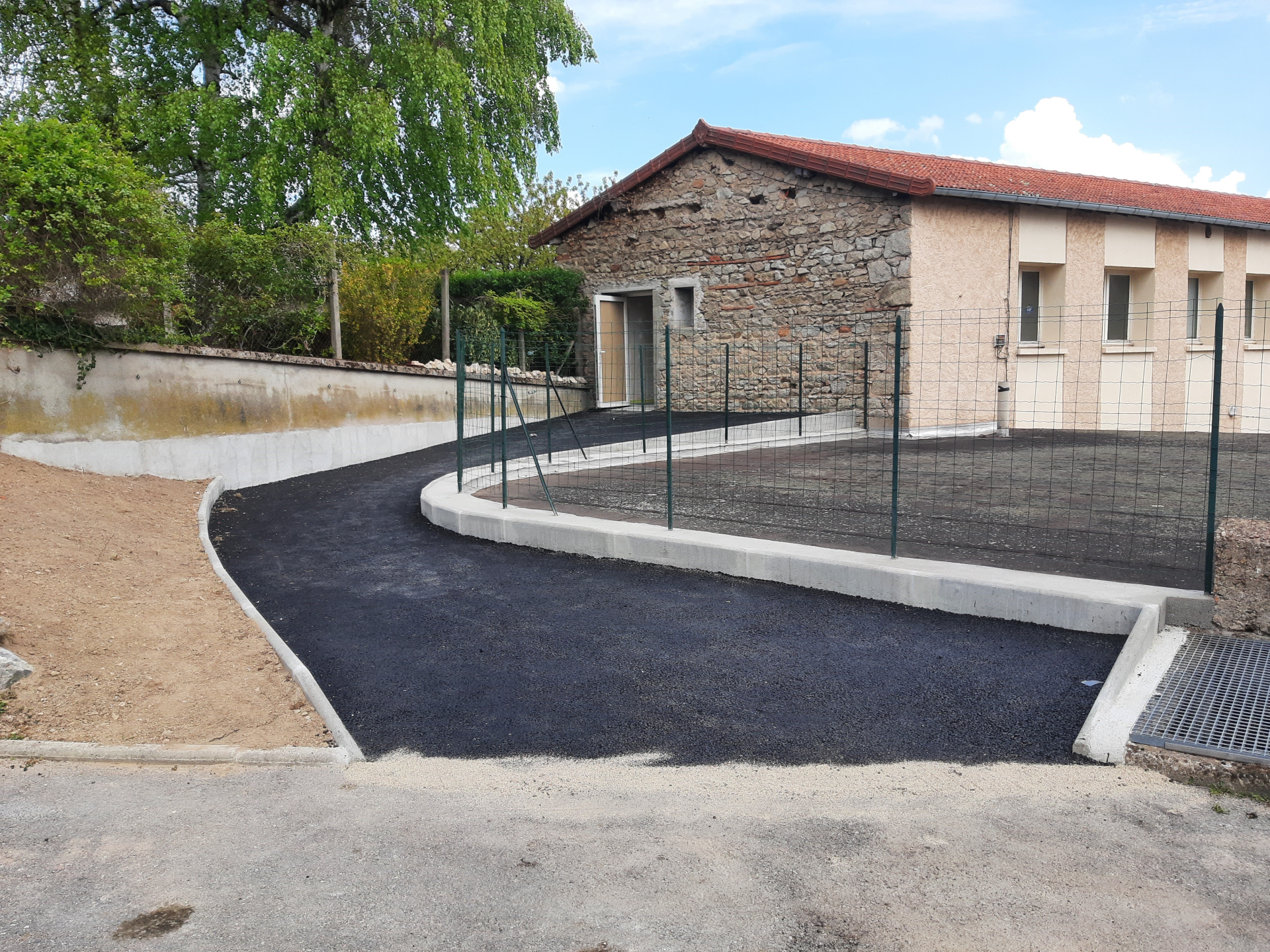 Bâtiment avec terrain de sport et clôture.