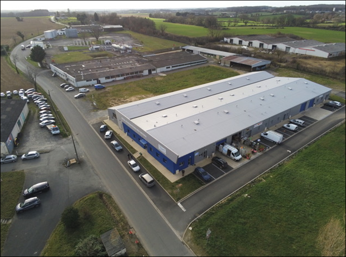 Vues aériennes d'un ensemble de bâtiments commerciaux et industriels, avec des véhicules garés et des terrains environnants.