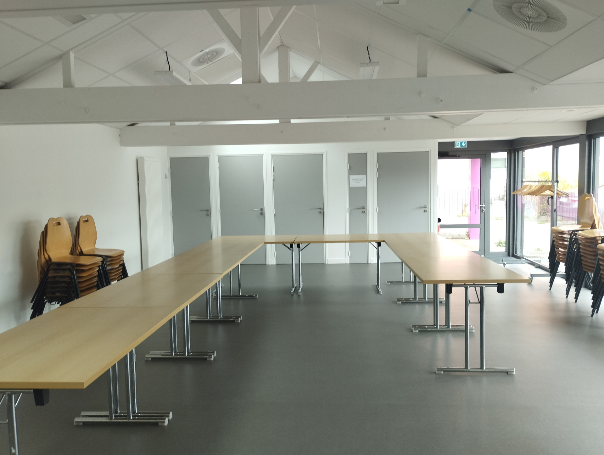 Salle avec tables, chaises, et lumières.