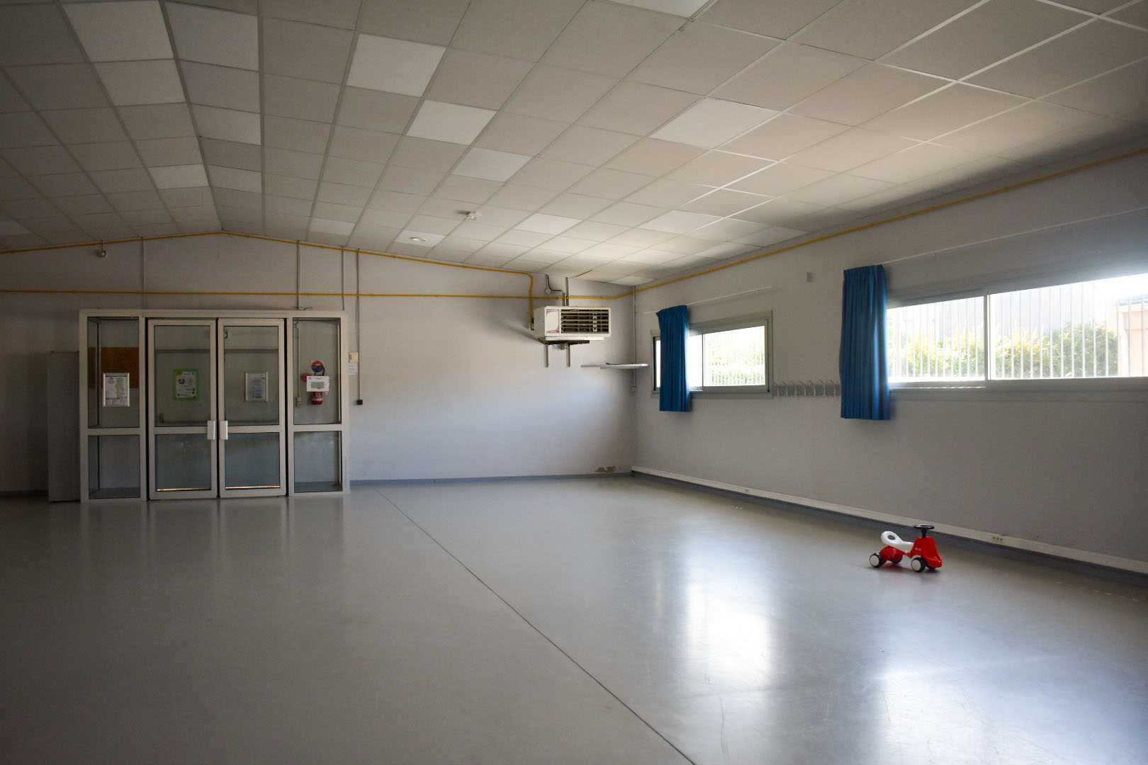 Salle vide avec portes, climatiseur, fenêtres et jouet.