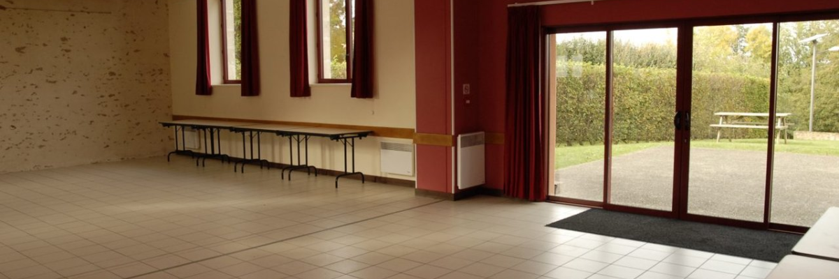 Salle avec tables, chaises, porte vitrée et fenêtres.
