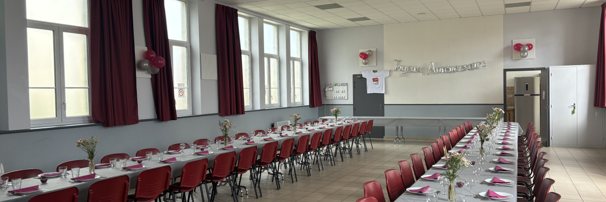 Salle avec tables, chaises, nappes, verres, fleurs et décorations.