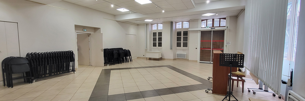 Salle avec chaises, pupitre, et fenêtres.