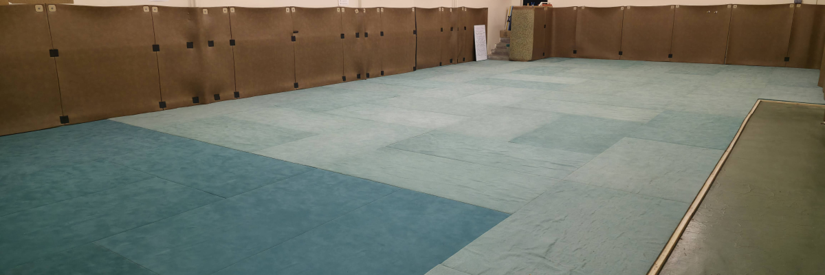 Salle avec sols colorés, casiers, rampes et panneaux.