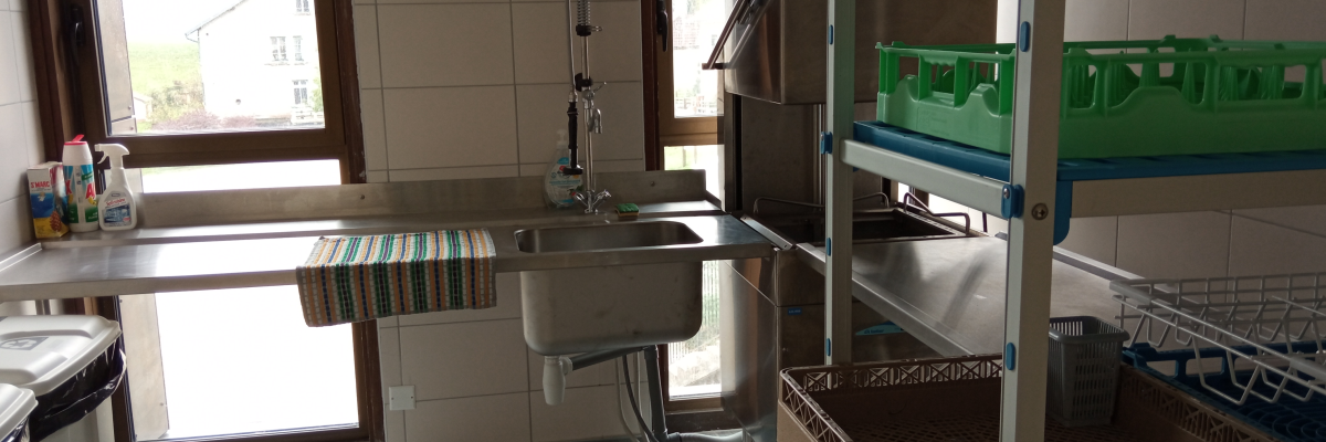 Cuisine avec évier, machine à laver, séchoir à vaisselle et plan de travail.