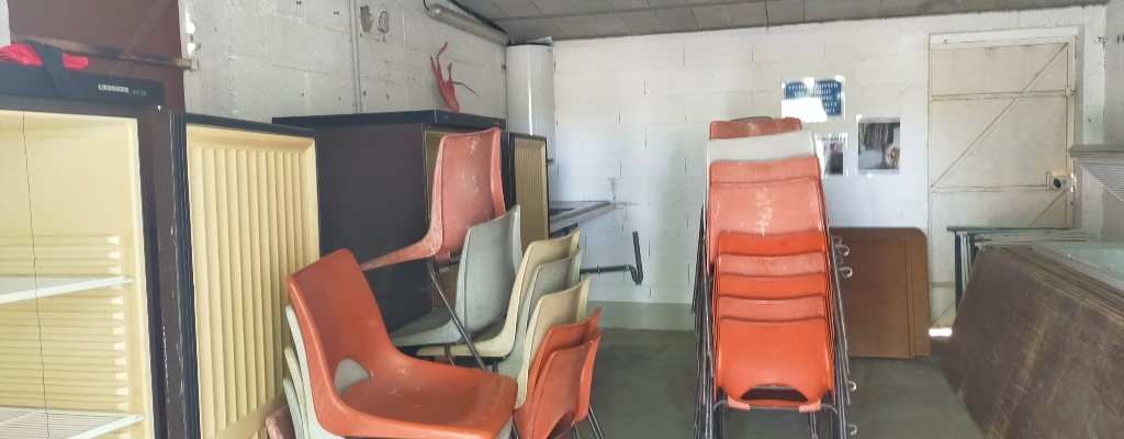 Pièces avec chaises, bureau, étagères et armoire.