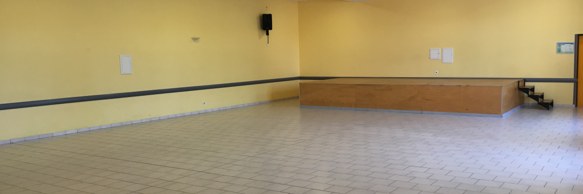 Salle vide avec éclairage, haut-parleur mural et banc.