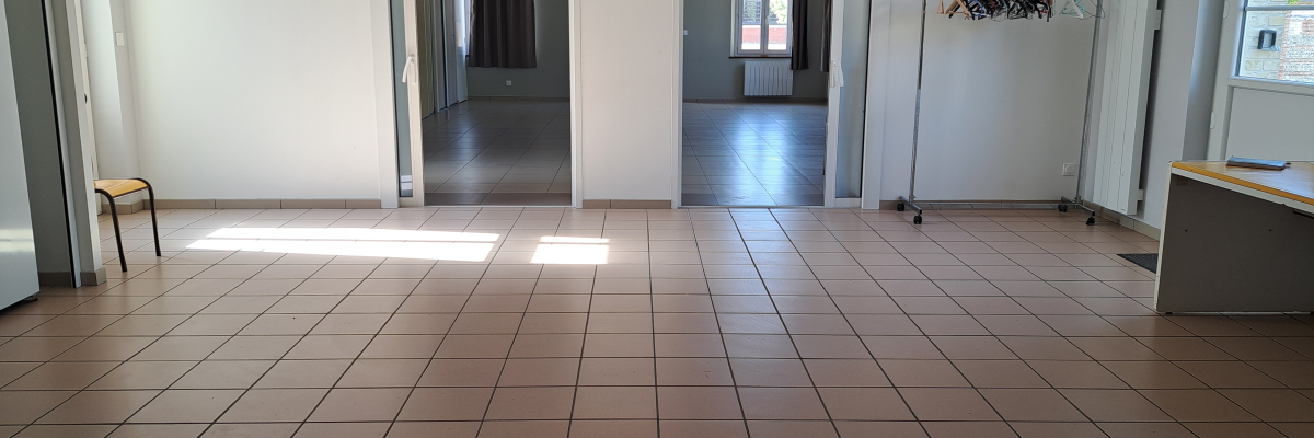 Pièce vide avec porte, fenêtre, tabouret, porte-manteau et bureau.