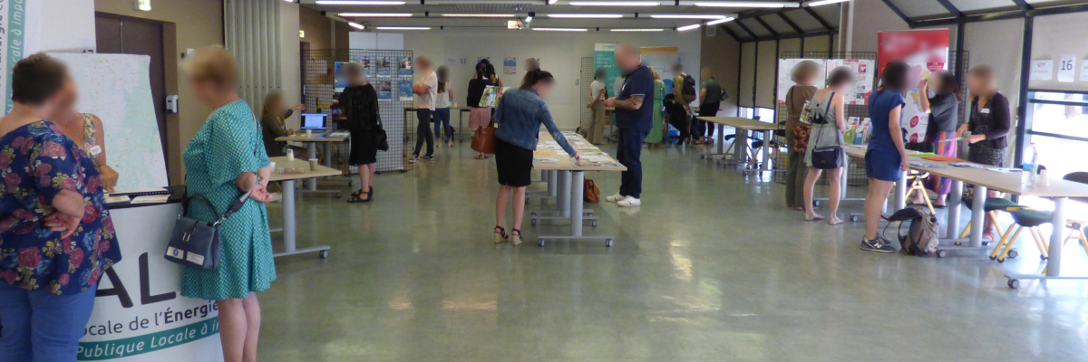 Salle avec tables, chaises, panneaux d'affichage, ordinateurs.