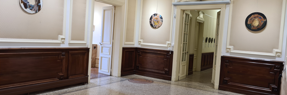 Hall d'entrée avec lustres, portes, boiseries et carrelage.