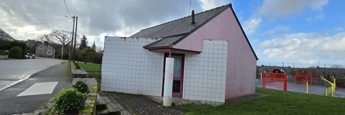 Maisonnette en périphérie de route avec terrain de jeux.