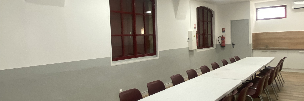 Salle avec table, chaises, portes en bois et éclairage au plafond.