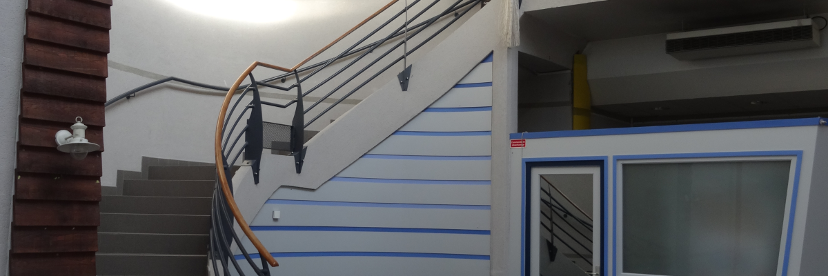 Escalier, rampe, ascenseur, porte vitrée, sol carrelé.