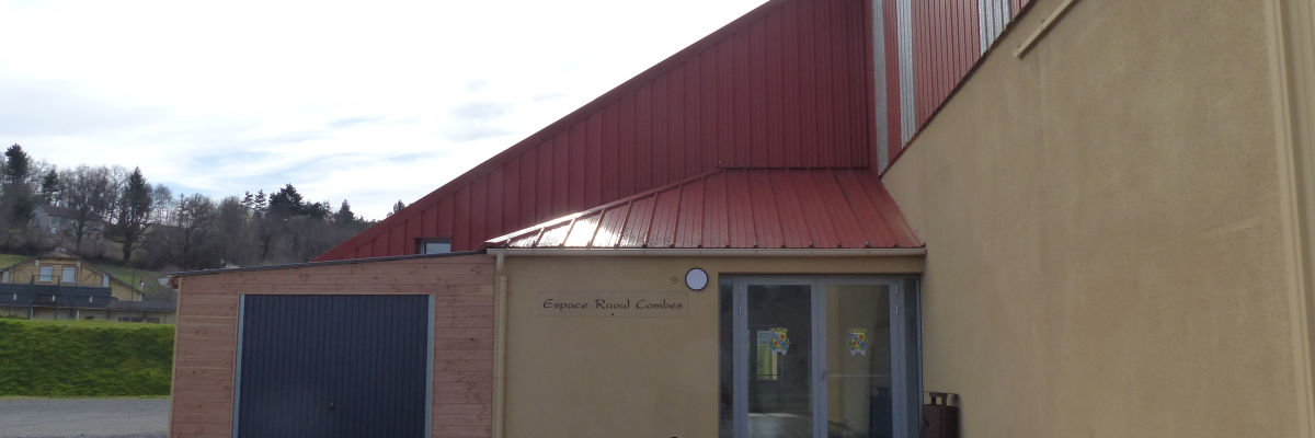 Bâtiment avec entrée, porte de garage et poubelle.