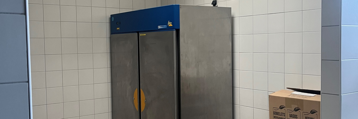 Pièce avec four industriel, table métallique et boîte en carton.