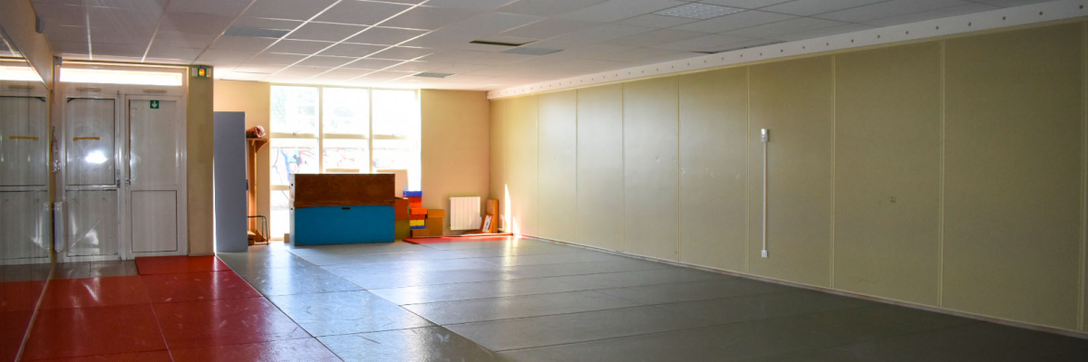 Salle vide avec sol multicolore, murs et portes.