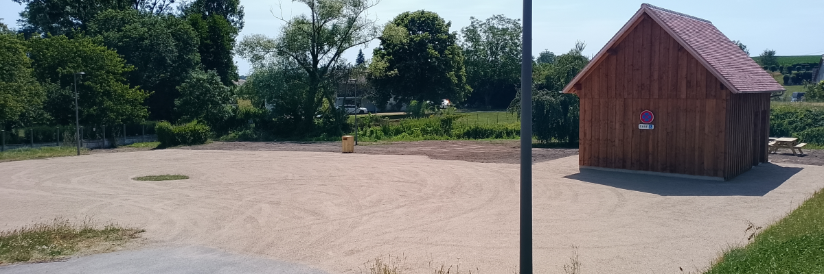 Terrain de beach volley avec cabane en bois et poteau.