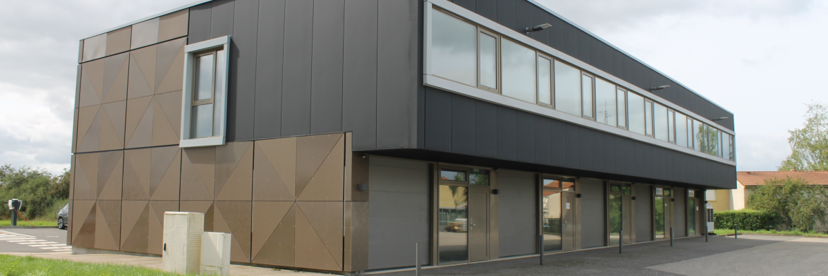 Bâtiment moderne avec façade en bois et verre, parking devant.