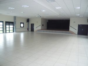 Salle vide avec portes, rampes, et lumière.