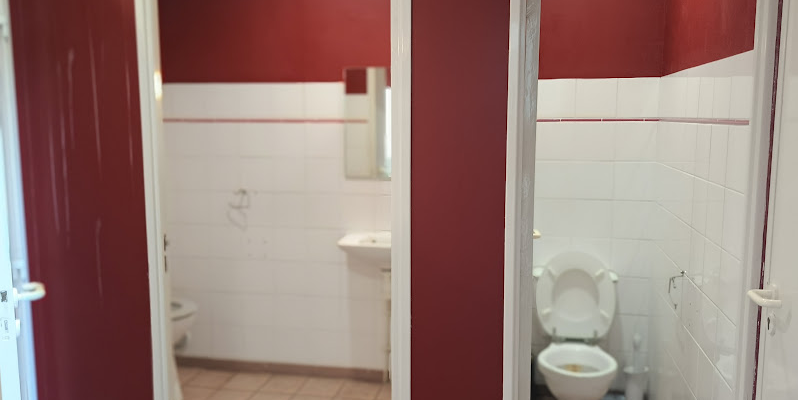 Toilettes avec lavabo, miroir, porte et toilettes.