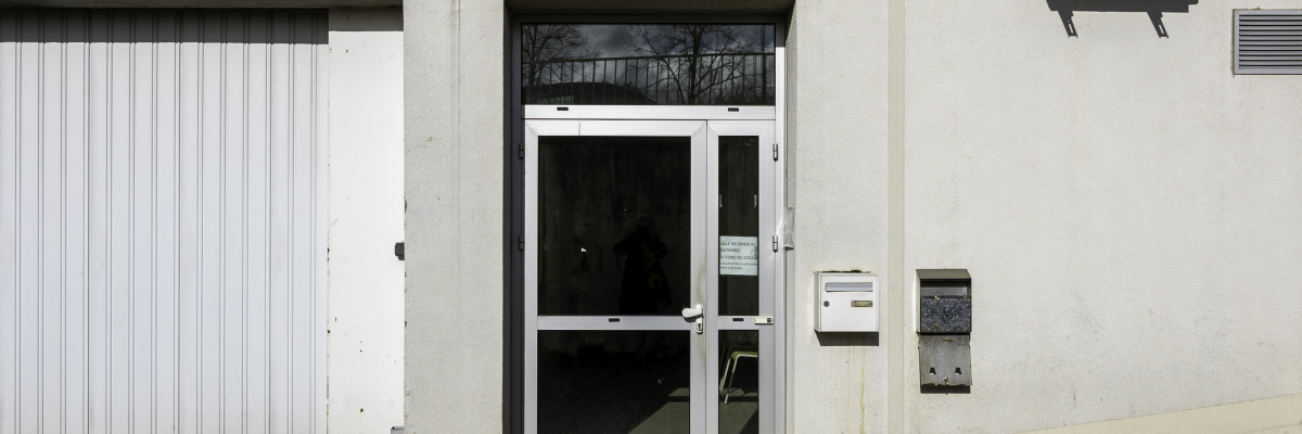 Extérieur avec porte, boîtes aux lettres, climatiseur et garage.