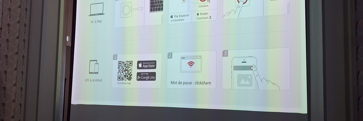 Une salle avec un écran affichant "Theatre Ville de Gorron", un logo, et des illustrations diverses.