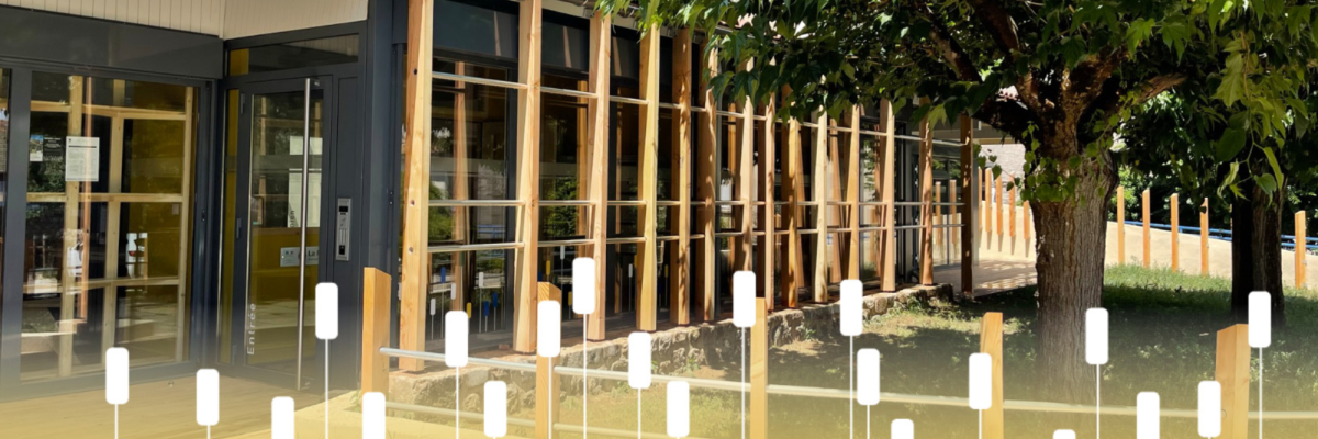 Bâtiment avec grandes fenêtres, arbre, clôture en verre et bois, sol jaune.
