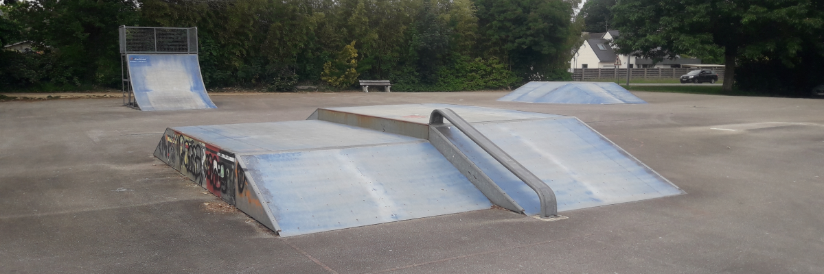 Skatepark avec rampes et modules.