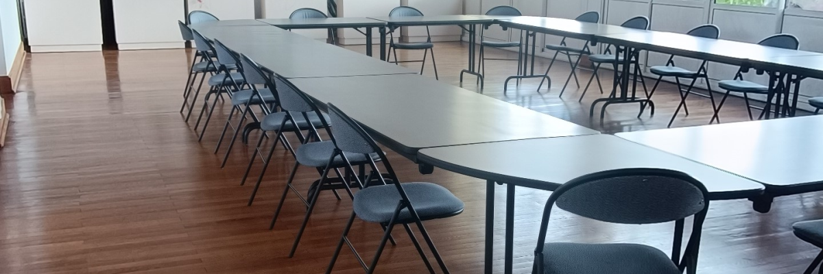 Salle avec tables, chaises, et plantes.