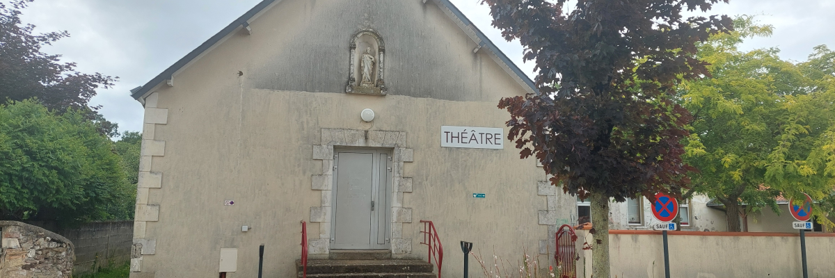 Bâtiment avec porte, escalier, panneaux, arbres, et panneau de signalisation.