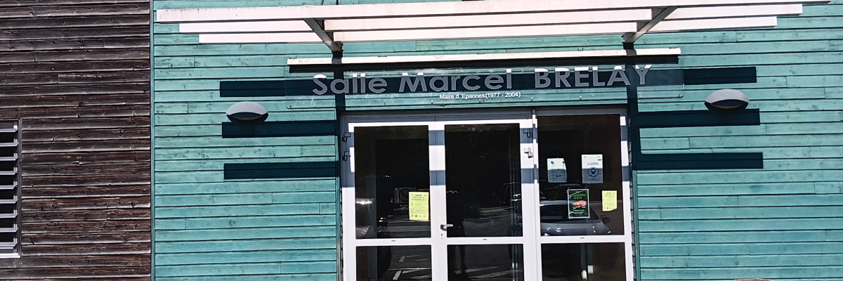 Bâtiment vert avec enseigne et entrée en verre.