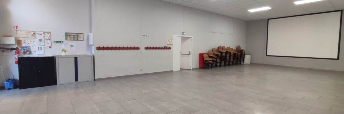 Salle avec chaises, évier, tableau et armoire.