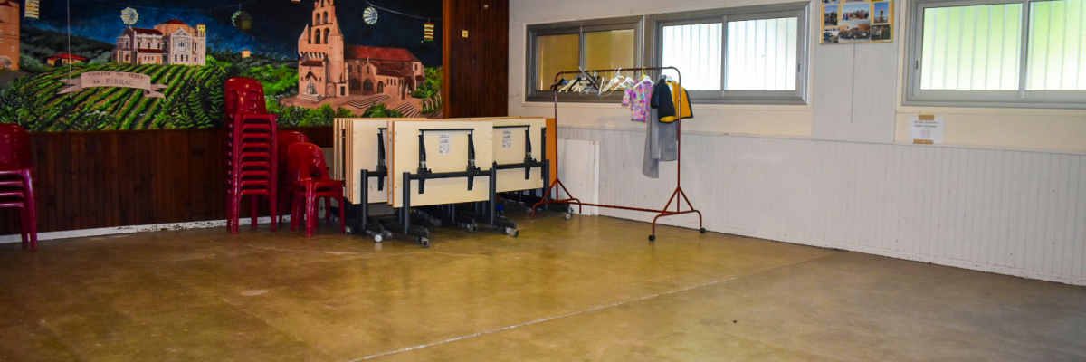 Salle avec chaises, table, étagère, porte-manteau, et peinture murale.