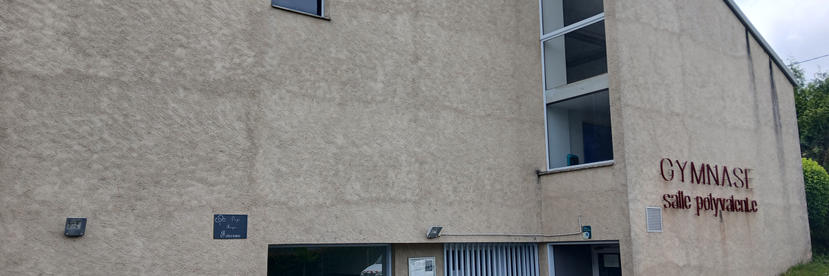 Bâtiment avec entrées, rampes et panneaux "Gymnase salle polyvalente".