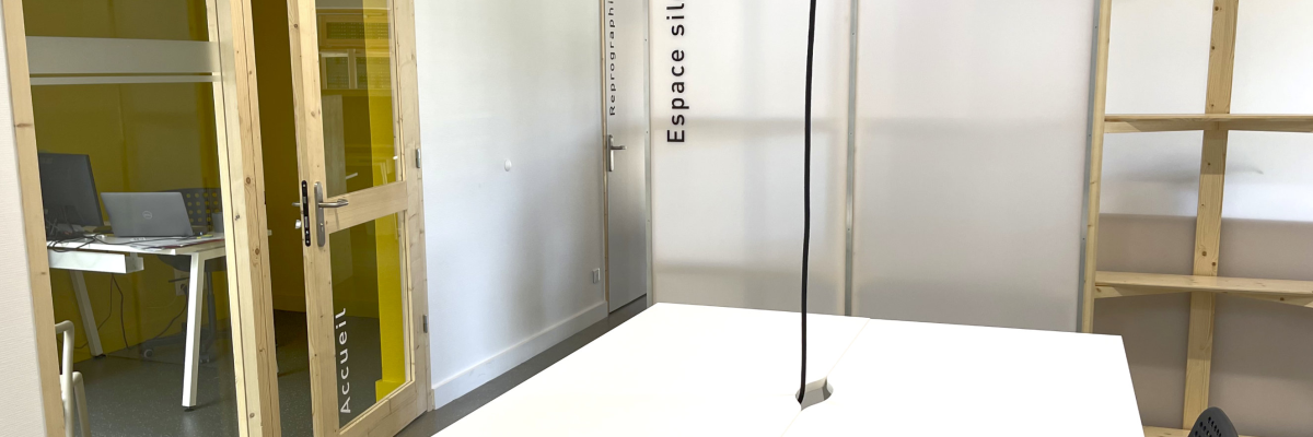 Salle avec table, chaises, porte vitrée et étagères.