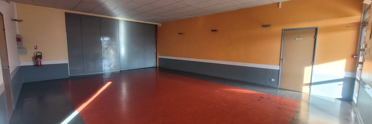Pièce avec mur, porte, extincteur et placard métallique.