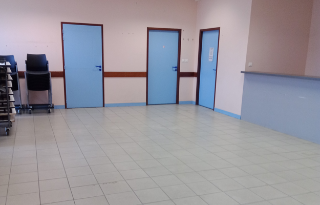 Pièces avec portes bleues et chariot métallique.